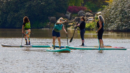 A group paddleboarding on the lakes at Sheffield Park and Garden